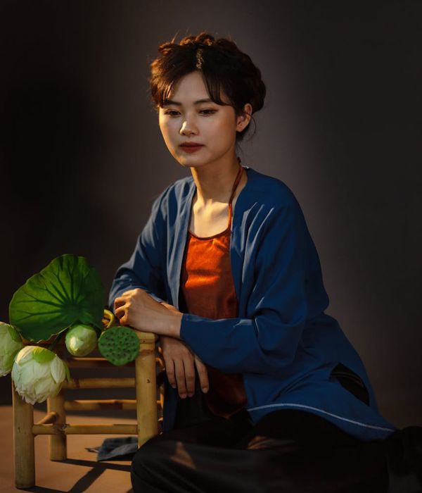 Woman sitting in a lotus pose with calm expression.